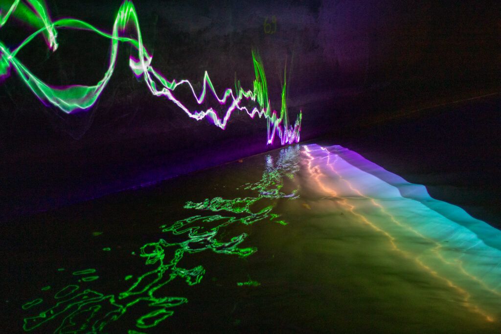 A laser projection by artist Romain Tardy reflects off the river Senne inside the Sewer Museum in Brussels